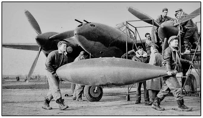 Two aircraft mechanics get ready to load a drop tank on a P-38
